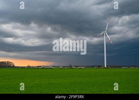 Sieversdorf, Germany. 19th Apr, 2021. Dark thunderclouds push over the landscape with a wind turbine in the district of Oder-Spree in East Brandenburg in the late evening before the sunset. Credit: Patrick Pleul/dpa-Zentralbild/ZB/dpa/Ģ����ý Live News Stock Photo