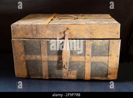 An old chest on a black background close-up. Wooden box upholstered in iron Stock Photo