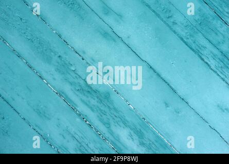 Old boards at an angle painted green fading from sunlight and weather. Stock Photo