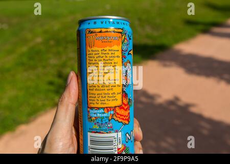 A hand holding a Monster Energy can drink, the panel explains the concept or idea of the drink. Stock Photo