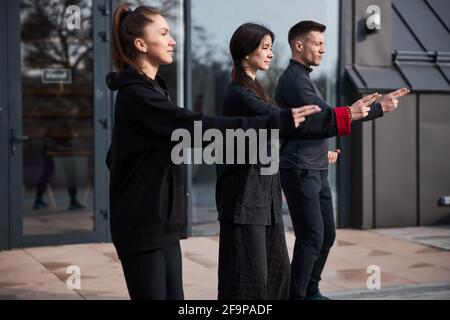 Tai chi practitioners in line moving hands with sticking fingers Stock Photo