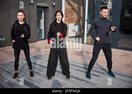 Three kung fu athletes pointing ahead with fingers Stock Photo
