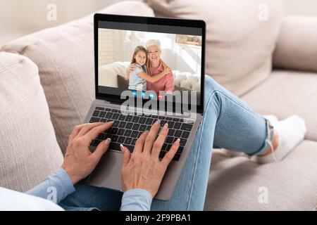 Unrecognizable Woman Using Laptop For Web Chat With Family Stock Photo