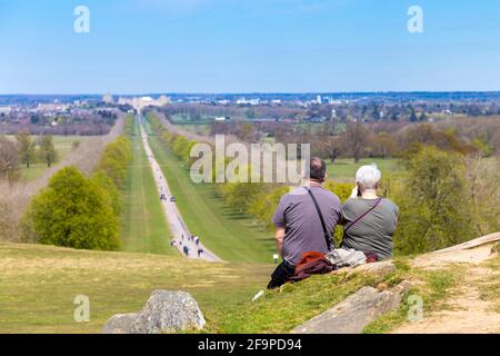 Couple enjoying view of Windsor Castle and the Long Walk from Snow Hill, Windsor, Berkshire, UK
