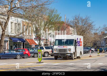 A Fedex Box truck parked in the middle of a main street making deliveries Stock Photo