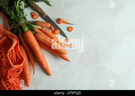 String bag, knife and carrot on white textured background Stock Photo