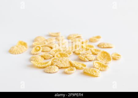 corn flakes isolated on white background, food ingredient, yellow corn cereal for breakfast, heap of sugar-coated corn flakes cutout Stock Photo