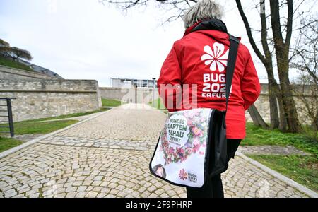 16 April 2021, Thuringia, Erfurt: A woman wears a jacket with the logo of the Federal Horticultural Show (BUGA) on the way to Petersberg. From 23 April to 10 October 2021, the summer festival with horticultural showcase is to take place on two exhibition sites in Erfurt. In addition, 25 BUGA outdoor locations are planned throughout Thuringia. Photo: Martin Schutt/dpa-Zentralbild/ZB Stock Photo