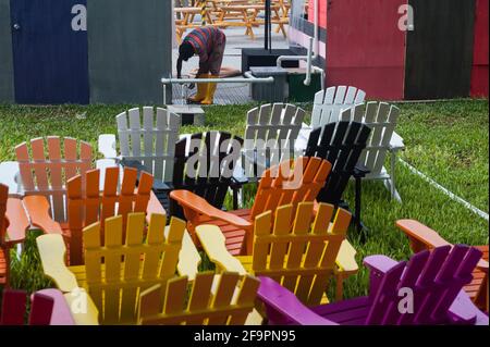 25.05.2017, Singapore, , Singapore - A South Asian migrant worker goes about his business in Marina Bay, while colorful chairs for an upcoming event a Stock Photo