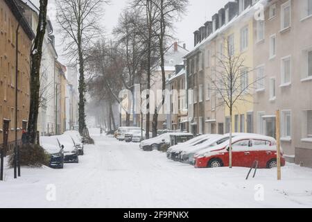 08.02.2021, Essen, North Rhine-Westphalia, Germany - Winter in the Ruhr area, snow-covered residential street in Holsterhausen, snow-covered cars on t Stock Photo