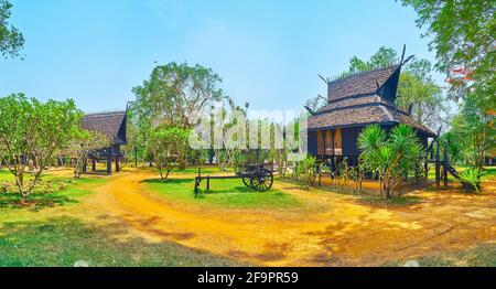 CHIANG RAI, THAILAND - MAY 11, 2019: Panorama of the Black House (Baan Dam) garden with building of the Guesthouse, green yuccas, rhododendrons and gr Stock Photo