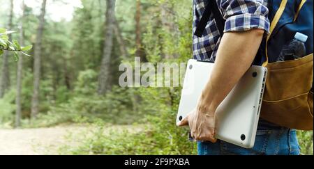 Young man holding laptop at the forest Stock Photo