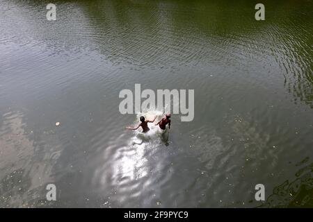 Dhaka, Bangladesh - April 20, 2021: It is summer in Bangladesh. Mischief in the water of Dhanmondi Lake in Dhaka for a little relief to the street chi Stock Photo