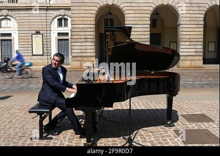 Milan, Italy. 20th Apr 2021. Conductor Alberto Veronesi performs at the piano during a flashmob in front of Teatro alla Scala theatre in Milan Italy on April 20, 2021 to raise awareness on the conditions of entertainment business workers due to the pandemic Credit: Piero Cruciatti/Alamy Live News Stock Photo