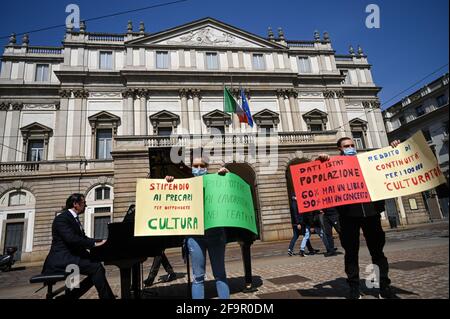 Milan, Italy. 20th Apr 2021. Performers and conductor Alberto Veronesi (at the piano)  participate at a flashmob in front of Teatro alla Scala theatre in Milan Italy on April 20, 2021 to raise awareness on the conditions of entertainment business workers due to the pandemic Credit: Piero Cruciatti/Alamy Live News Stock Photo