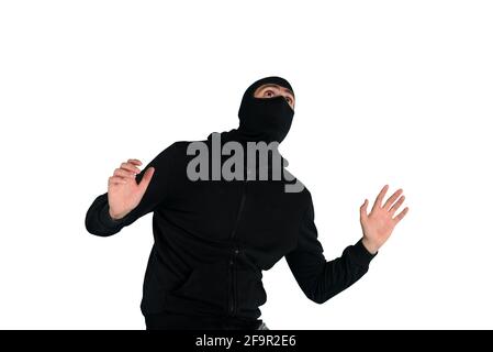 Thief with balaclava was spotted trying to steal in a apartment. Scared expression Stock Photo