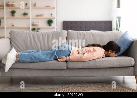 Exhausted Sleepless Young Woman Lying On The Couch Stock Photo