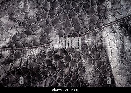 Artificial black reptile leather texture background. Fake leather texture. Stock Photo