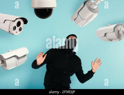 Thief with balaclava was spotted trying to steal in a apartment from the video surveillance system. Scared expression Stock Photo