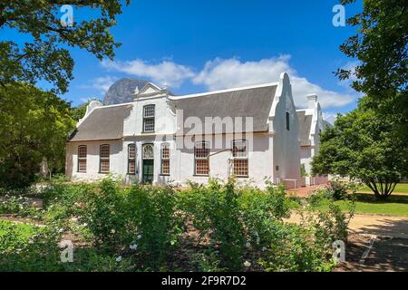 Historic Rhone Homestead Manor House from 1795 at Boschendal Winery near Franschhoek, South Africa with Hottentots Holland Mountains in the background Stock Photo