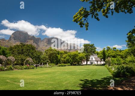 Historic Rhone Homestead Manor House from 1795 at Boschendal Winery near Franschhoek, South Africa with Hottentots Holland Mountains in the background Stock Photo