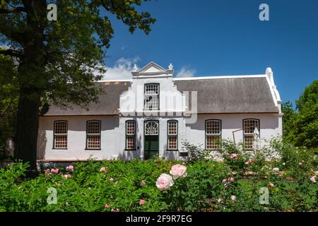 Historic Rhone Homestead Manor House from 1795 at Boschendal Winery near Franschhoek, South Africa with Hottentots Holland Mountains in the background Stock Photo