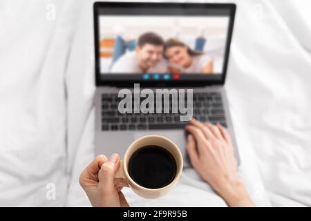 Virtual Meeting. Unrecognizable Female Drinking Coffee And Having Video Call With Friends Stock Photo