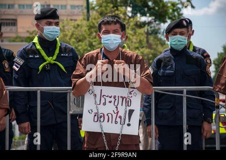 A protester seen dressed as prisoner with chains wrapped around