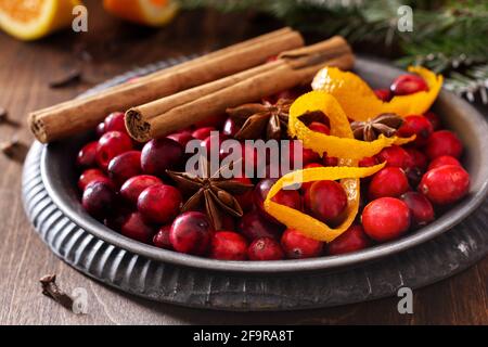 Ingredients for making mulled wine with cranberries. Orange, cinnamon, cranberry berries, cloves, anise and sugar. Christmas atmospheric retro concept Stock Photo