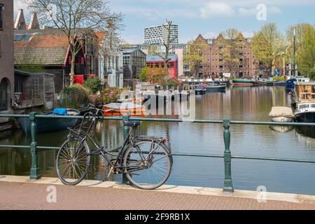 Bicycle parked on a bridge over a canal in Amsterdam. Stock Photo