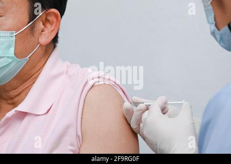 Doctor giving COVID-19 Vaccine shot to patient for can help stop pandemic, COVID-19 vaccines can help reduce the transmission of the new coronavirus Stock Photo