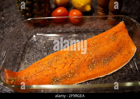Raw wild caught salmon fish fillet seasoned and ready to bake in baking dish. Stock Photo