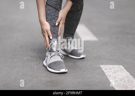 Shin Splints. Female Jogger suffering from sport trauma while running outdoors Stock Photo
