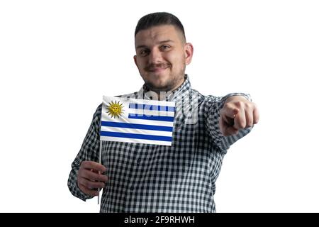 White guy holding a flag of Uruguay and points forward in front of him isolated on a white background. Stock Photo
