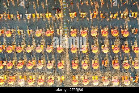 Rows of striped multi colored beach umbrellas and its shadows from above, Vieste, Foggia province, Gargano, Apulia, Italy Stock Photo