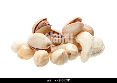 peeled hazelnuts and cashew with salted pistachio in shell, pile   of deferent nuts close-up of protein healthy food isolated on white background, nob Stock Photo