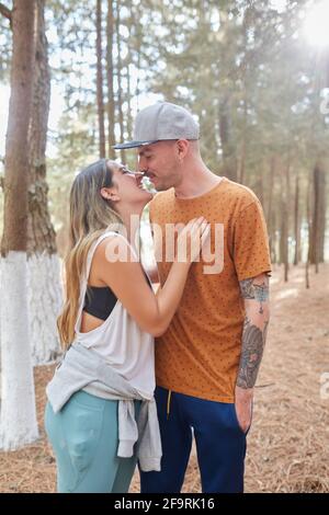 happy engaged couple kissing in the middle of the forest Stock Photo