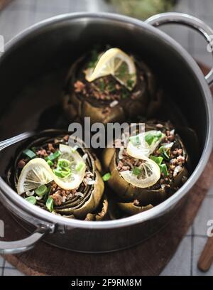 Artichokes stuffed with rice and meat in cooking pot, Aegean cuisine Stock Photo