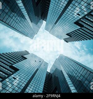 glass reflective office buildings against blue sky with clouds a Stock Photo