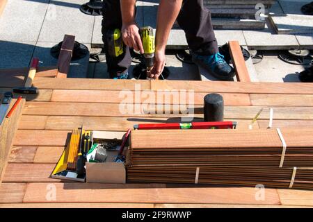 Carpenter building wooden deck construction, Ipe wood deck installation worker, decking hardwood terrace Stock Photo