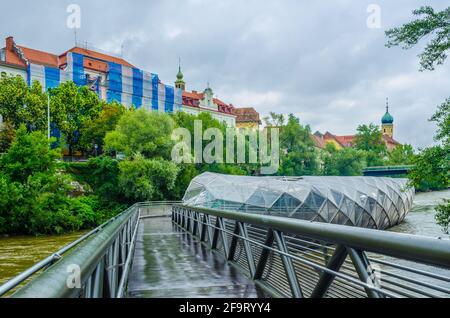 Island on Mur river is a modern steel and glass construction with a cafe and a plenty of space to sit during hot sunny days, Styria, Graz, Austria Stock Photo