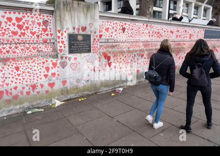 Red hearts painted in memory of people who have died of Covid-19 during the coronavirus pandemic at the National Covid Memorial Wall on 13th April 2021 in London, United Kingdom. The wall is  a place for people to come to reflect or to write messages or the names of lost loved ones. The wall represents a tribute to the approximately 150,000 British victims pandemic.