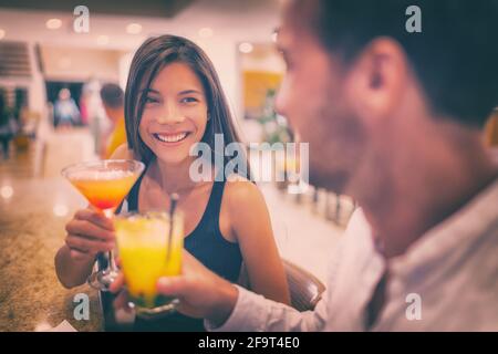 Bar drinking cocktails young couple in love dating talking with drinks at restaurant at night. People at restaurant with alcoholic cocktail beverage Stock Photo