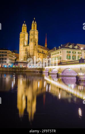 Munsterbrucke and Grossmunster church reflecting in river Limmat, Zurich, Switzerland Stock Photo