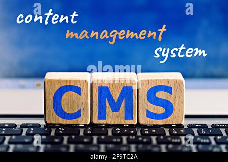 photo on CMS (content management system) theme. wooden cubes with the abbreviation "CMS", and the inscription "content management system", on blue bac Stock Photo