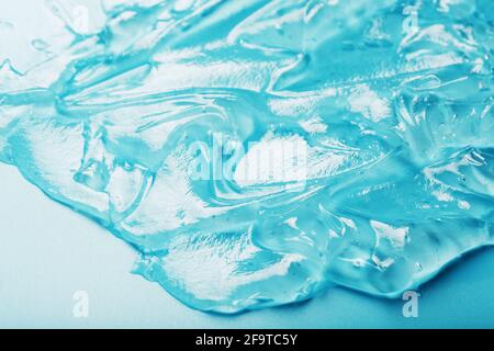 Gel with hyaluronic acid in the form of a smear of glossy texture on a cyan background. Antibacterial cosmetics Stock Photo