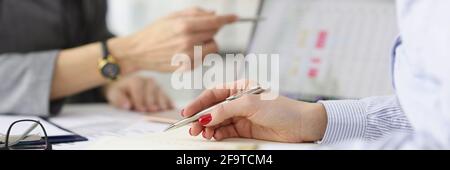 Two colleagues discussing commercial metrics of business on tablet. Stock Photo