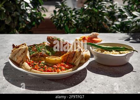 Delicious rack of lamb with hummus sauce, Traditional Arabic, Turkish, Israeli cuisine. Roasted lamb, top view. Stock Photo