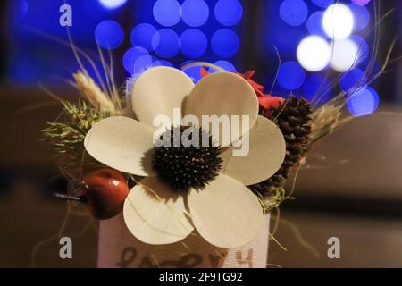 Artificial flower on table with bokeh blue lights on background Stock Photo