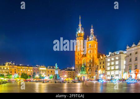 Night view of the church of Saint Mary with statue of adam mickiewicz on the rynek glowny main square in the polish city Cracow/Krakow. Stock Photo